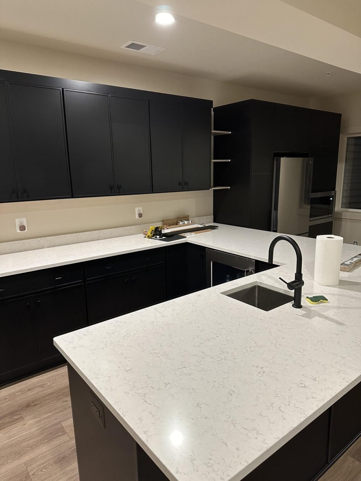 ZEFI GROUP kitchen renovation with dark cabinetry and a center island